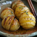 Des patates dorées coupées en tranches, parfumées au thym et poivre, servies dans une assiette.
